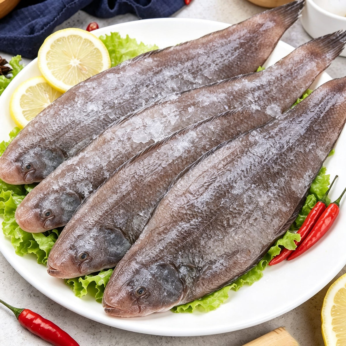 Frozen whole sole arranged on a platter with lemon and chilli